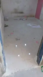 عامل يقوم بإصلاح بلاط متضرر ومعالجة الهبوط في الأرضيات باستخدام مواد ترميم قوية