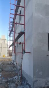 عامل يقوم بترميم واجهة منزل باستخدام لياسة خارجية مقاومة للعوامل الجوية