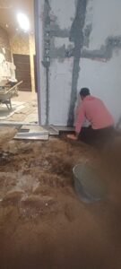 عامل يقوم بترميم الجدران الداخلية ومعالجة التشققات باستخدام مواد احترافية في خميس مشيط