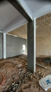 أعمال تلييس الجدران الداخلية والأعمدة في مبنى قيد التجهيز
